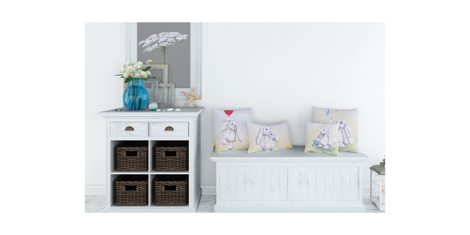 Four cushions on a white seating bench, each featuring a different image of a rabbit art illustration. A shelving unit with flowers and ornaments on top and a picture of a white flower on the wall above.