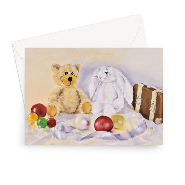 A greeting card featuring a teddy bear, a white rabbit, and colorful ornaments, shown with a white envelope behind it.