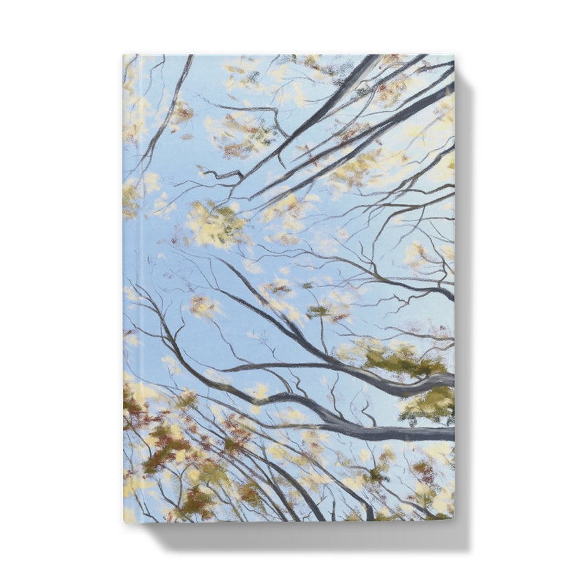 Notebook with tree canopy and leaf design on a blue background. Front cover
