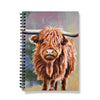 Notebook with a Scottish highland cow illustration on the cover