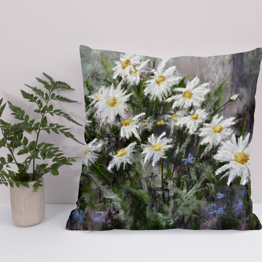 White daisy flower floral throw cushion next to a green plant.