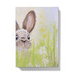 Notebook with a rabbit illustration on a grassy field cover. Front cover