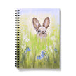 Notebook with a rabbit illustration on the cover, featuring a rabbit peeking from grass and flowers.