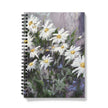 Notebook with a floral design on the cover featuring white flowers on a colourful background