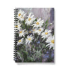 Notebook with a floral design on the cover featuring white flowers on a colourful background